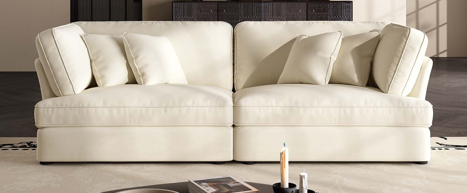Living room with white leather sofa set and glass coffee table in a modern showroom.