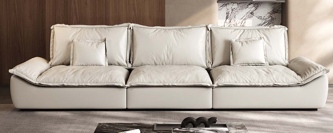 Beige leather sofa with multiple cushions in modern home setting